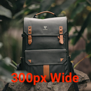 A dark grey backpack with brown leather accents and a top handle